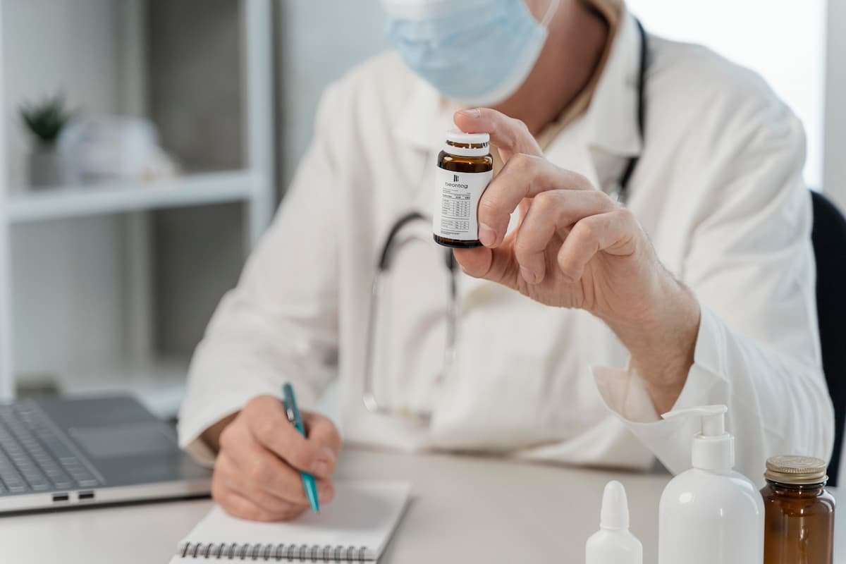 Doctor holding a pharmaceutical vial with a self-adhesive label in a clinical setting.