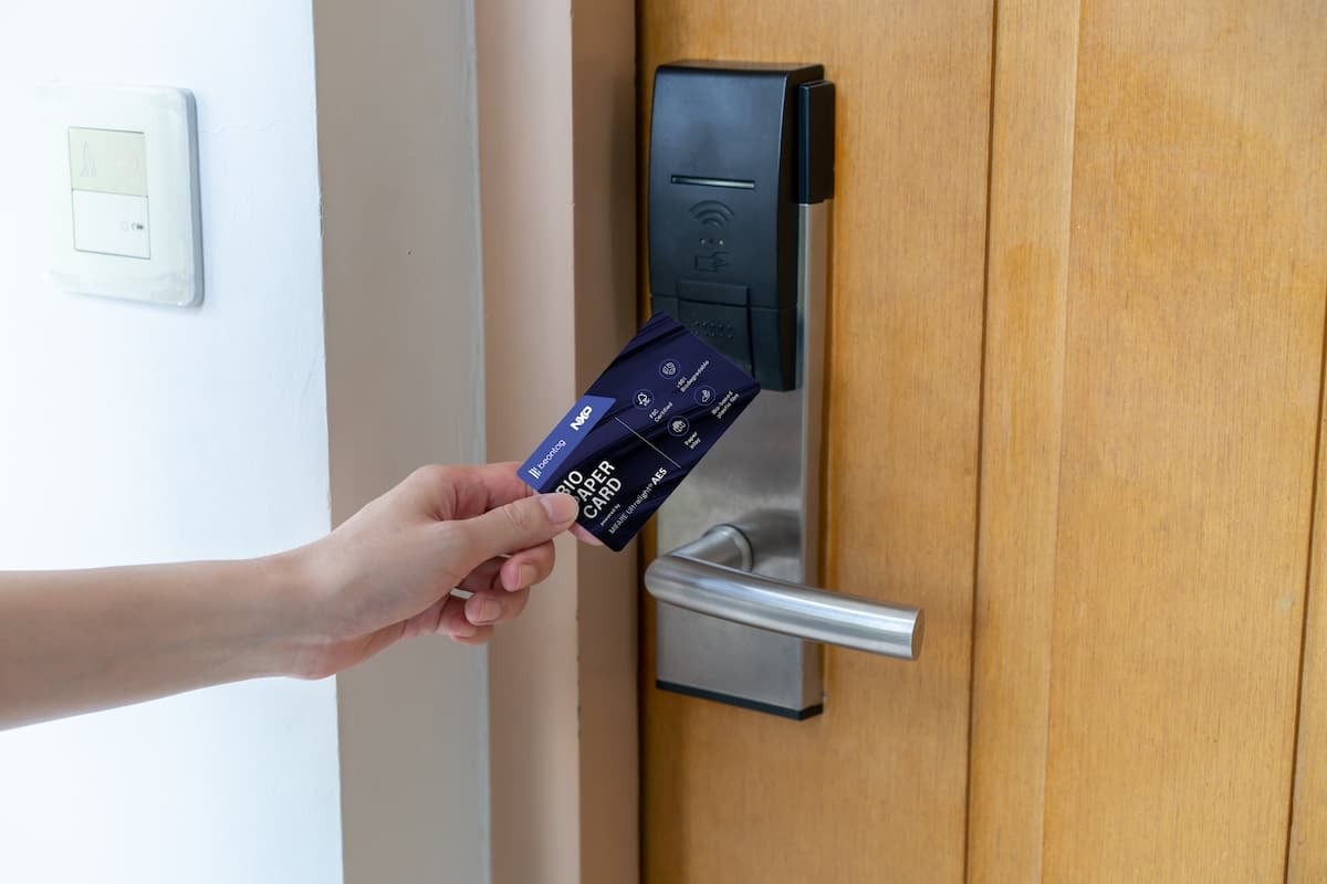 Person holding an RFID card near an electronic door lock, demonstrating RFID access control for secure, contactless entry in commercial or residential environments.