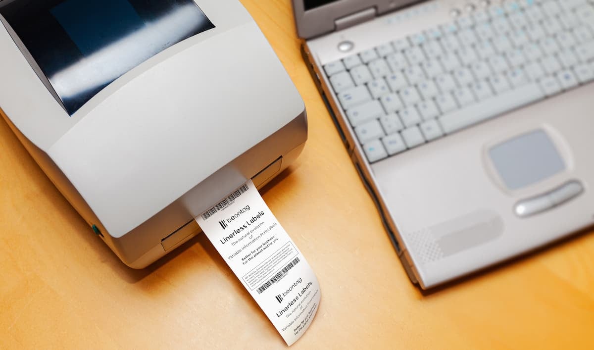 Impresora de etiquetas con rollo linerless, ejemplo de uso en comparación de térmica directa vs termotransferencia.