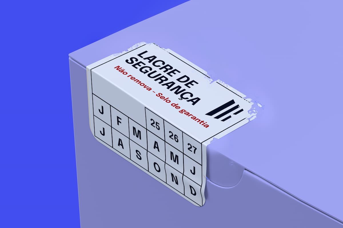 Lacre de segurança (estilo VOID) parcialmente rasgado em uma caixa de produto, com o texto 'Lacre de Segurança – Não remova – Selo de garantia' e uma grade com meses e anos.